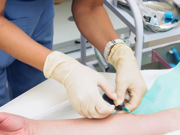 Médico que tira sangue do braço do paciente feminino para exame — Fotografia de Stock