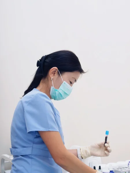Asiatiska sjuksköterska rita blod att förbereda undersökning i laboratorium — Stockfoto