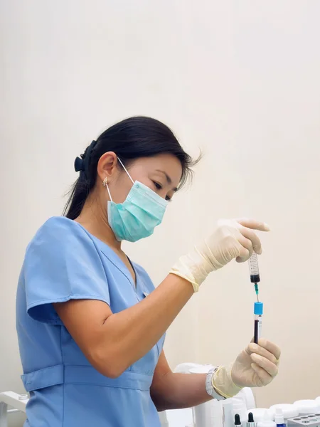 Азиатская медсестра сдаёт кровь для подготовки экспертизы в лаборатории — стоковое фото