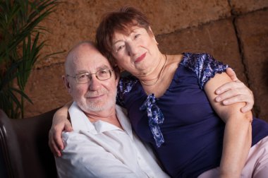 Tatlı yaşlı çift kahverengi bir oturun