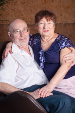 Tatlı yaşlı çift kahverengi bir oturun