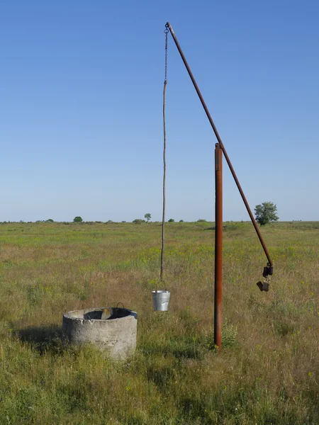 Well with bucket and swing arm for pulling up water — Stock Photo, Image