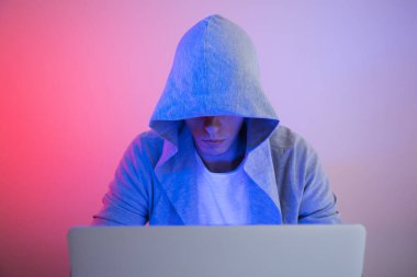 Oyuncu dizüstü bilgisayarla oynar. Programcı kodu yazar. Renkli arka planda bir adam