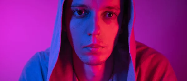 Portrét mladý muž expresivní pohled na kameru s červeným a modrým světlem Stock Obrázky