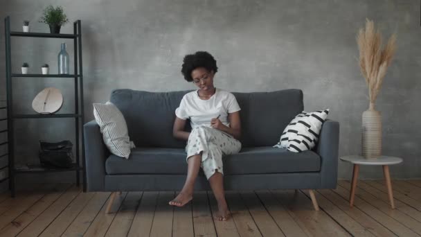 African American girl writes in a notebook in a cozy room — Stock Video