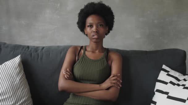 Ongelukkig Afro-Amerikaanse vrouw zitten op de bank, het meisje is erg boos zitten op de bank van haar appartement. — Stockvideo