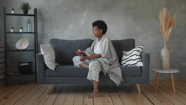 Happy african American young woman sit relax on cozy couch and happy with the message on the phone — Stock Video