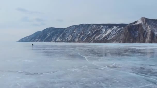 Озеро Байкал. Молодой фотограф ходит по льду, наслаждаясь видами и фотографируя. — стоковое видео