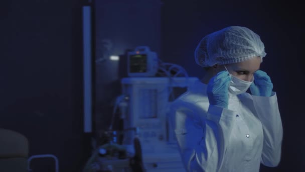 Portrait of Young Female Doctor in Medical Mask Looking at Camera. The doctor Holds the Cones in his Hands — Stock Video