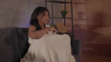 Kanepede oturup televizyon izleyen Afrikalı Amerikalı kız. Evde kal.