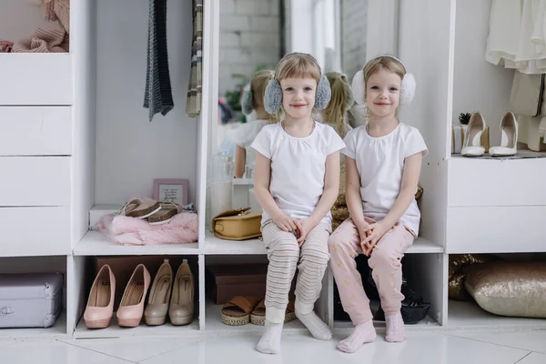 Twin Girls Try On Things in Their Mothers Modern Dressing Room. Royalty Free Stock Images