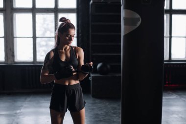 Genç kız soyunma odasının arka planında atmosferik fitness odasında duruyor.