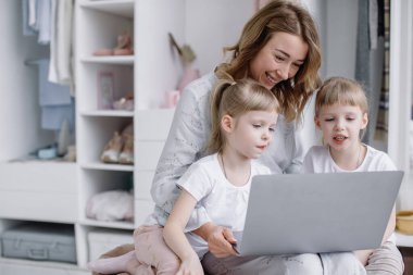 İkiz kızları olan genç bir anne rahat dairesinde internetten bir şeyler seçiyor.