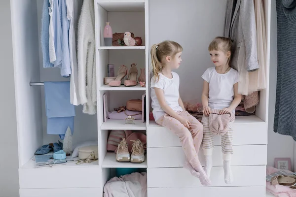 Dvojčata dívky vyzkoušet na věci v jejich matkách moderní šatny. Stock Snímky