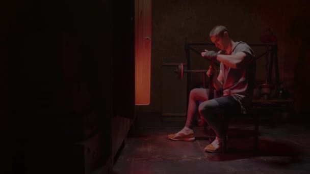 Mann bereitet sich in der Umkleidekabine auf Boxtraining vor. Rotes Neonlicht — Stockvideo
