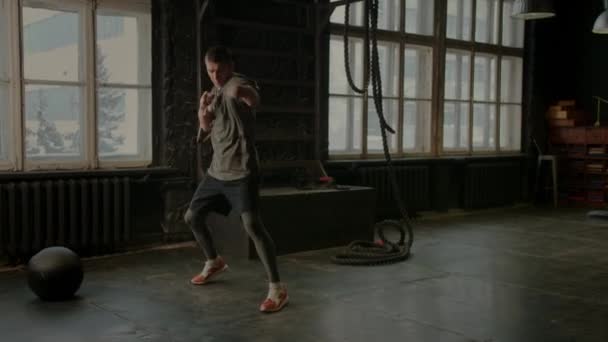 Крутой боец в боксерских повязках тренируется в спортзале. Смешанные боевые искусства — стоковое видео