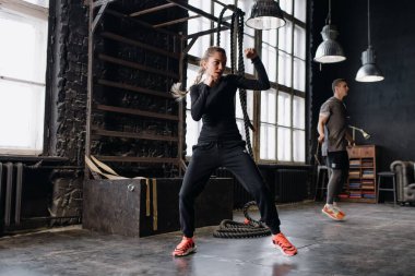 Boks eldivenli havalı kadın boksör spor salonunda antrenman yapıyor. Karışık dövüş sanatları