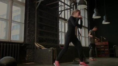 Boks eldivenli havalı kadın boksör spor salonunda antrenman yapıyor. Karışık dövüş sanatları