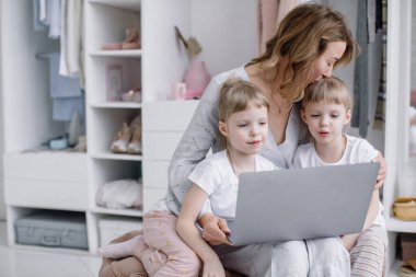 İkiz kızları olan genç bir anne rahat dairesinde internetten bir şeyler seçiyor.