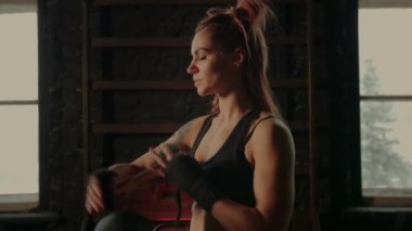 Sportif kız boks bandajı, dövüş antrenmanından önce siyah el bandı, spor salonunda savunma egzersizi.