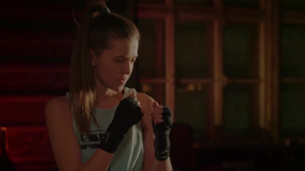 Cool vrouwelijke vechter in bokshandschoenen traint in de sportschool. Gemengde vechtsporten — Stockvideo