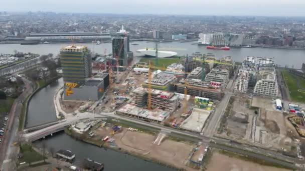 Amsterdam den 19 december 2020, Nederländerna Buikslotermeer byggarbetsplats nya lägenheter vid floden Ij. tvärs över centralstationen i centrum av Amsterdam. — Stockvideo
