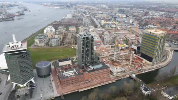 Amsterdã, 19 de dezembro de 2020, Países Baixos Buikslotermeer canteiro de obras novos apartamentos no rio Ij. através da estação central no centro da cidade de Amsterdã. — Vídeo de Stock
