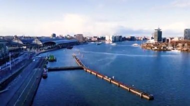 Amsterdam Merkez Havayolları zaman göstergesi, Amsterdam 'daki şehir merkezi ve Lj nehri, Hollanda feribotları ve toplu taşıma araçları insansız hava aracı görüntüsü üzerinden uçuyor..