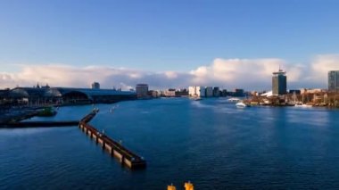Amsterdam Merkez Havayolları zaman göstergesi, Amsterdam 'daki şehir merkezi ve Lj nehri, Hollanda feribotları ve toplu taşıma araçları insansız hava aracı görüntüsü üzerinden uçuyor..