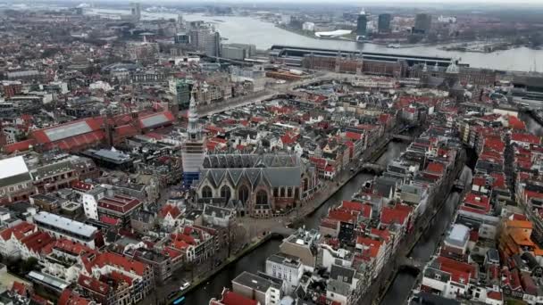El Oude Kerk en el centro de la ciudad de Amsterdam en el distrito de luz roja vista aérea drone estación central en el fondo — Vídeo de stock