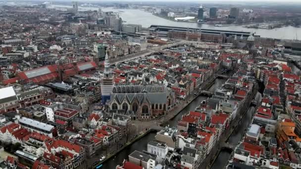 Oude Kerk w centrum Amsterdamu w dzielnicy czerwonych latarni z widokiem na stację centralną w tle — Wideo stockowe