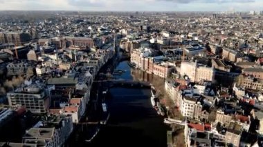 Amsterdam şehir merkezindeki Amstel nehrinin üzerinden Hollanda 'daki Munttoren ve Muntplein' e doğru uçuyor güneşli bir kış gününde..