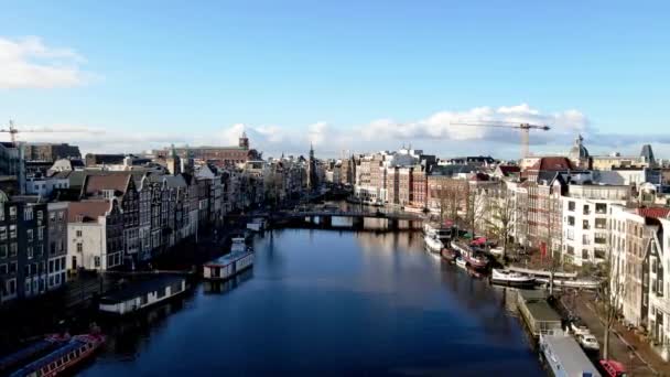 アムステルダムは晴れた冬の日にオランダのMuntrenとMuntpleinに向かって市内中心部のアムステル川を飛んでいます. — ストック動画