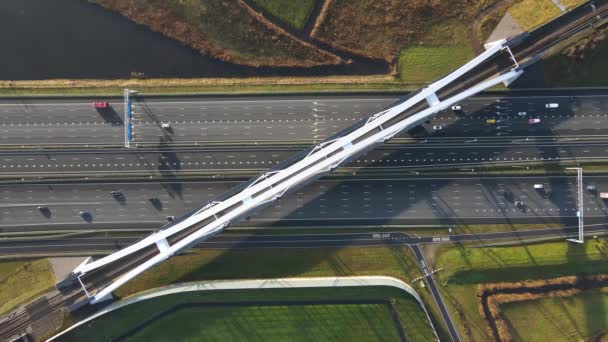 Zandhazenbrug most łukowy nad autostradą A1 w Muiderberg, Holandia Widok z góry z ruchu pod mostem i przejazdu pociągiem — Wideo stockowe