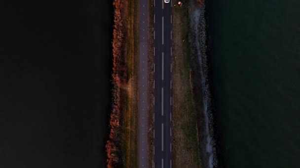 Aerial top down view of an open road with water surrounding it. The Netherlands near Marken. — Stock Video