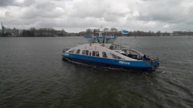 Amsterdam, 14 Mart 2021, Hollanda 'da. GVB toplu taşıma feribotu Lj nehri anteninden geçiyor. Feribotu takip ediyorum..