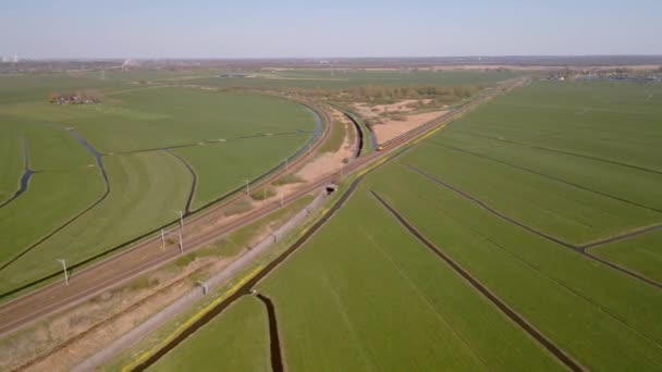 Weesp yakınlarındaki bir raydaki yolcu treni tipik bir Hollanda manzarasında toplu taşıma altyapısının hava görüntüsü. — Stok video