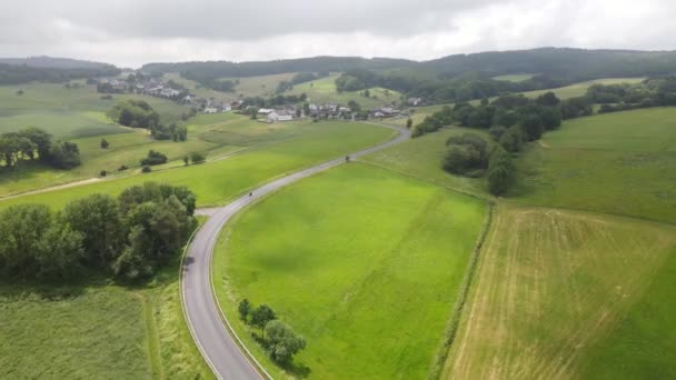 夏には日当たりの良い草原の丘を通ってドイツのアイフェルツイスト道路. — ストック動画