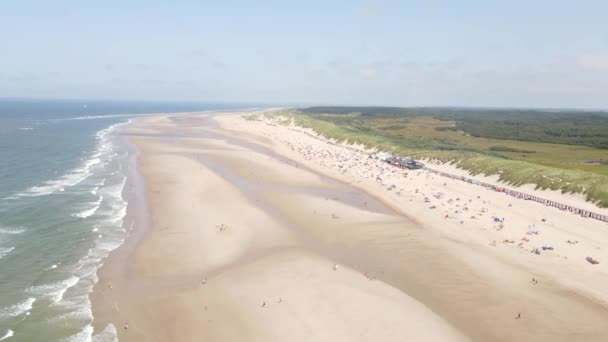 Widok z lotu ptaka na małe domy na plaży wzdłuż wybrzeża i wydmy w Oostkapelle, Zeeland, Holandia. — Wideo stockowe