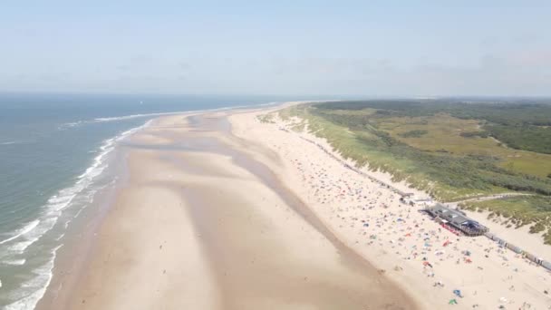 Widok z lotu ptaka na małe domy na plaży wzdłuż wybrzeża i wydmy w Oostkapelle, Zeeland, Holandia. — Wideo stockowe