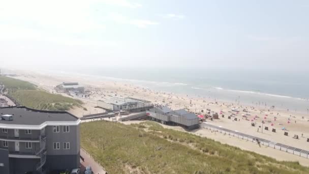 Egmond aan Zee, 25 липня 2021, Нідерланди. Лінія узбережжя пляжу у чудовий сонячний день у Нідерландах. Люди, що займаються розмноженням води на сонці та на пляжі.. — стокове відео