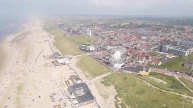 Egmond aan Zee, 25 Temmuz 2021, Hollanda. Hollanda 'da güzel güneşli bir günde sahil şeridi. Sucu insanlar güneşte ve plajda dinleniyorlar..