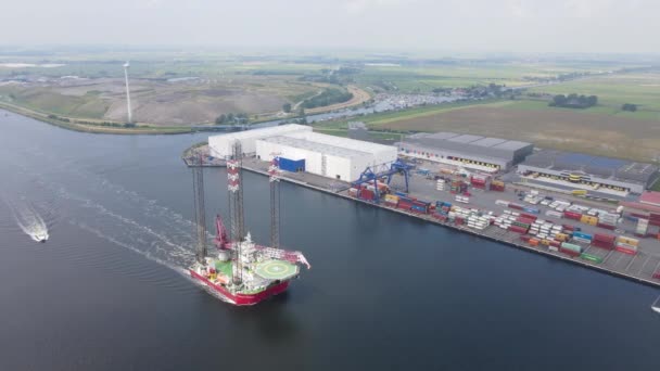 Drohnenaufnahme einer Meeresplattform mit einem Kran auf der Spitze, der durch den Amsterdam Westpoort segelt, Niederlande. — Stockvideo