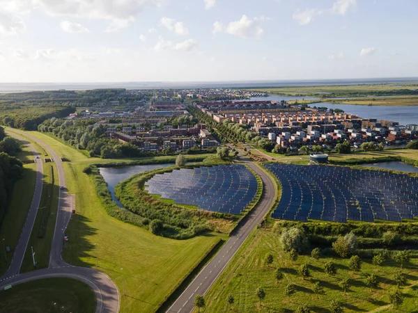 Moderní novátorská obytná čtvrť v Almere, podél vodní plochy, včetně solárního panelového pole. Nizozemsko, Flevoland. — Stock fotografie