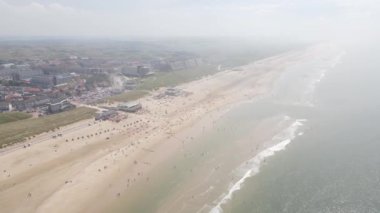 Egmond aan Zee, 25 Temmuz 2021, Hollanda. Hollanda 'da güzel güneşli bir günde sahil şeridi. Sucu insanlar güneşte ve plajda dinleniyorlar..