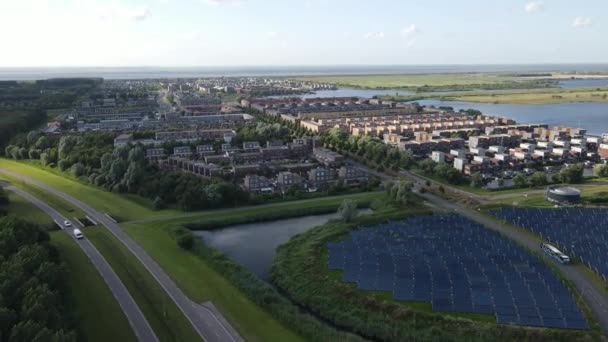 Moderne innovatieve woonwijk in Almere, langs de waterkant, waaronder zonnepaneelveld. Nederland, Flevoland. — Stockvideo