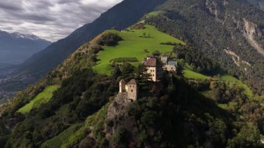 Juval kalesi, dağlık bir tepede şato elma bahçesi vally manzaralı. Tirol Alpleri. İtalya. Hava aracı videosu.