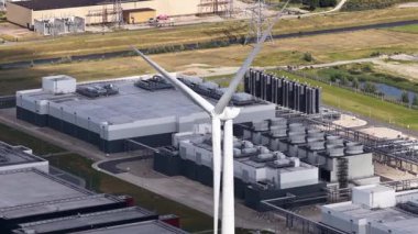Rüzgar türbini, Eemshaven, Groningen, Hollanda 'da geniş ölçekli veri merkezi genişlemesi ile yenilenebilir enerjiyi sembolize ediyor. AI, IT, internet altyapısı. Hava görünümleri.