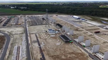 Musselkanaal, Hollanda, Groningen ili, 14 Eylül 2025: Omexom, TenneT için yeni standart tasarıma göre ilk 380 kV yüksek voltaj alt istasyonunu inşa etmektedir. İnşaatın havadan görüntüsü