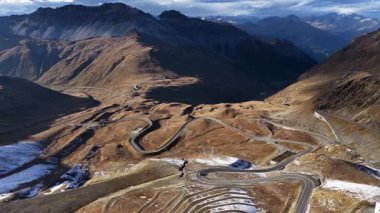 Stelviopass, yüksek dağlar ve uçurumlarla çevrili yılan yolu. Gün batımında hava aracı videosu.